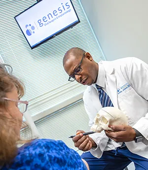 Dr. Antoine Johnson showing a patient an example on a plastic skull