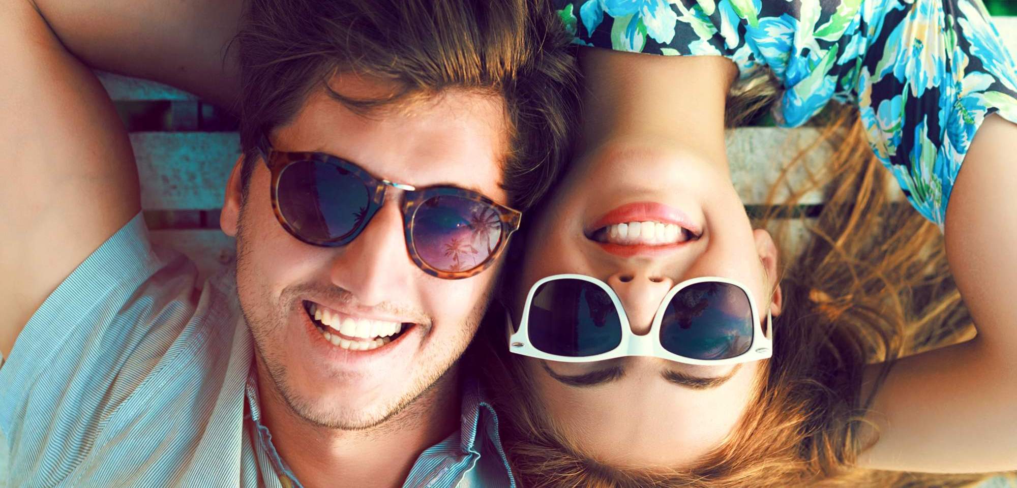 Two people laying down with sunglasses